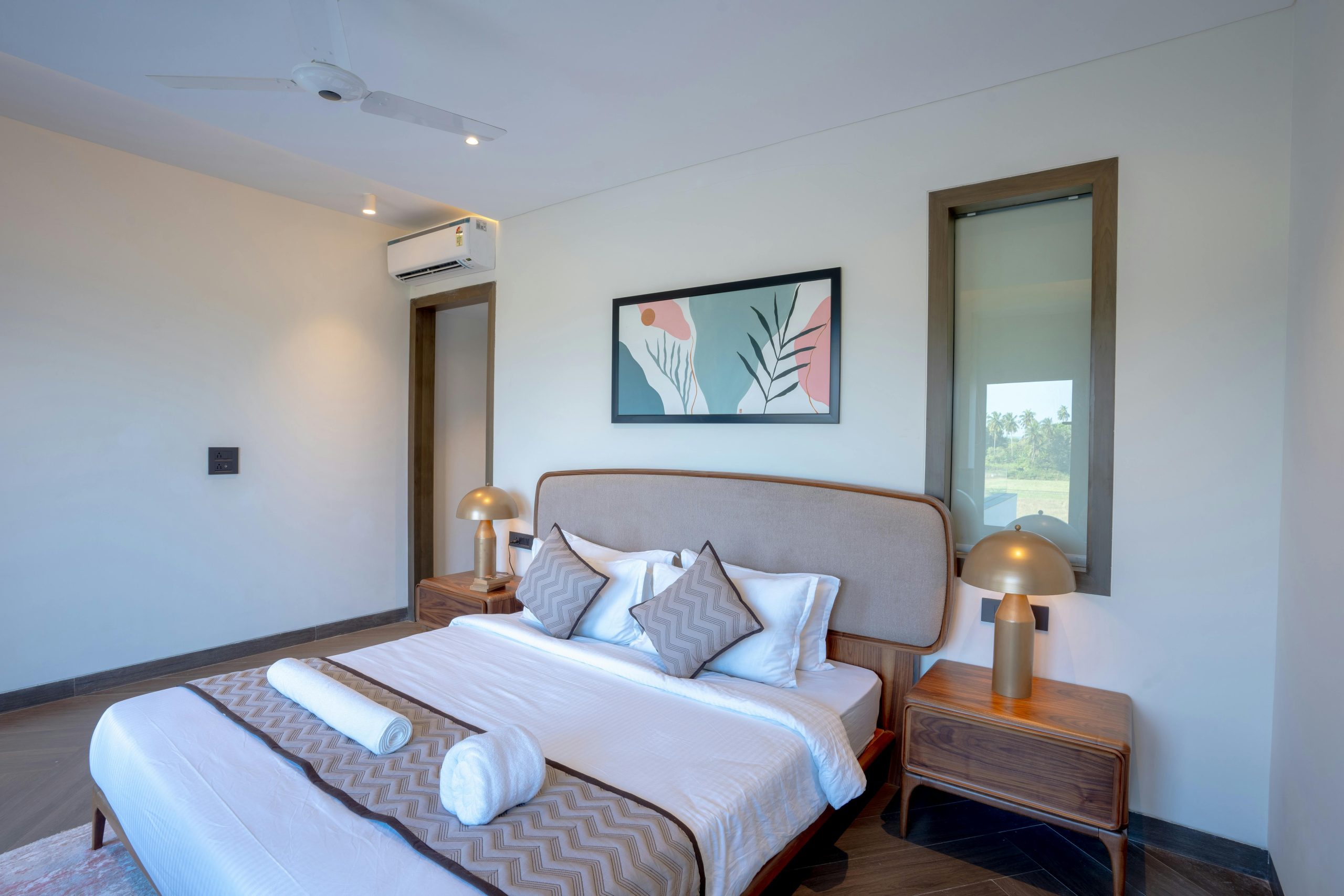 A stylish luxury bedroom with modern decor in a Saligao villa, featuring elegant furnishings.